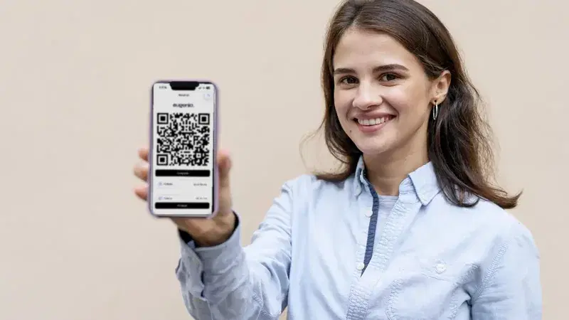 Mujer muestra en su celular el pase QR de Eugenia para entrar al condominio