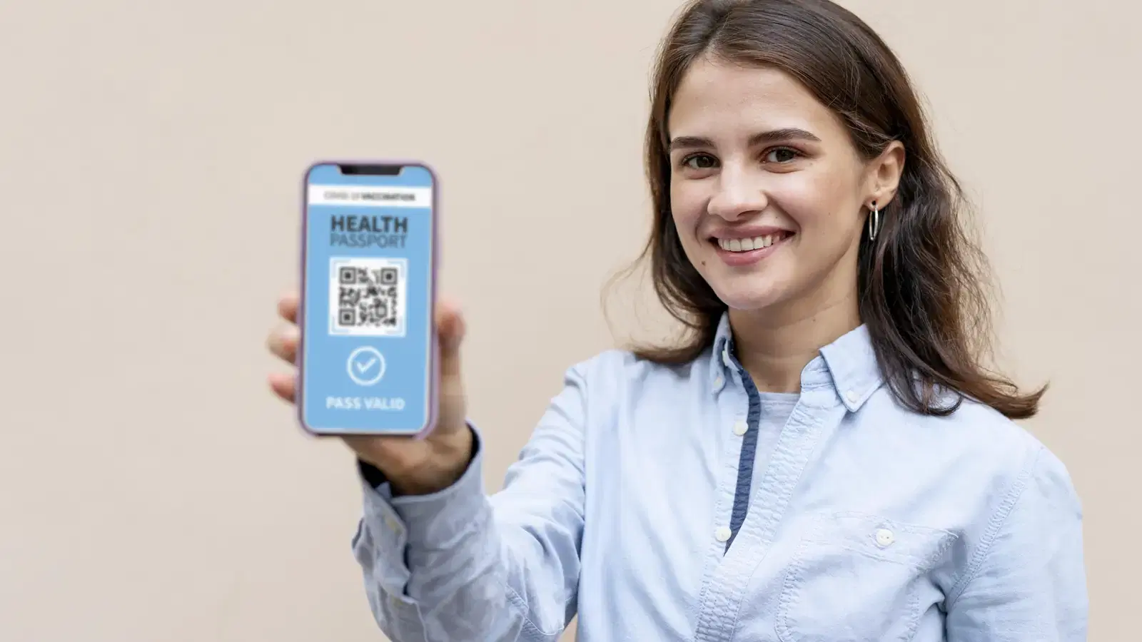Mujer sonriente muestra un código QR en la pantalla de su celular