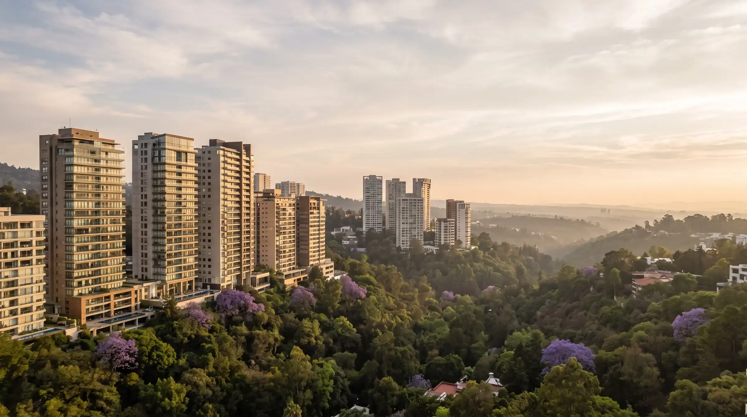 Torres de condominios residenciales entre barrancas arboladas y jacarandas en Interlomas, Ciudad de México